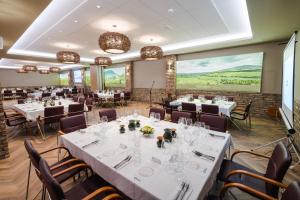 a banquet room with white tables and chairs at Bock Hotel Ermitage in Villány