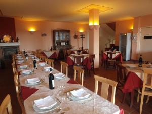 a dining room with tables and chairs with wine bottles at Agriturismo Sette Colli in Ferrere