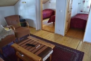 - un salon avec un canapé, une chaise et une table dans l'établissement Männikkölän Pirtti, à Nurmes