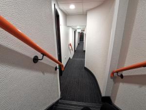 a long hallway with stairs and an orange hand rail at easyHotel Leeds in Leeds