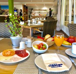 a table with plates of food and a glass of orange juice at Apartamentos Tigaiga Suites in Puerto de la Cruz