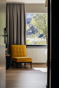 a yellow chair sitting in front of a window at ION Adventure Hotel, Nesjavellir, a Member of Design Hotels in Nesjavellir