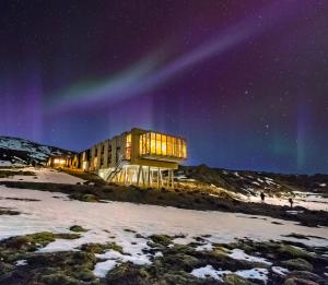 a building under the northern lights in the sky at ION Adventure Hotel, Nesjavellir, a Member of Design Hotels in Nesjavellir