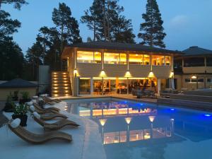 ein großes Haus mit einem davorliegenden Swimmingpool in der Unterkunft Hölick Havsresort & spa in Hudiksvall