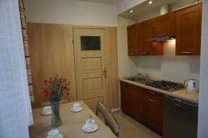 a kitchen with a table with a vase of flowers on it at Agroturystyka Słoneczny Dom in Lublin