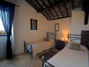 a bedroom with two beds and a window at Historic house in Montefiascone