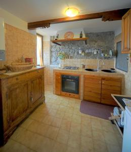 a large kitchen with wooden cabinets and a sink at Historic house in Montefiascone