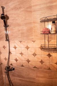 a shower in a bathroom with a tile wall at New Star Residence in Burgas City