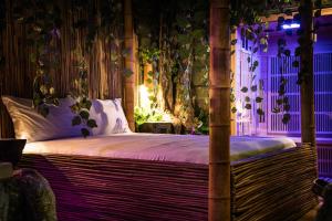 una camera da letto con un grande letto con illuminazione viola di MagicSuite Guest House Roma Portuense a Roma