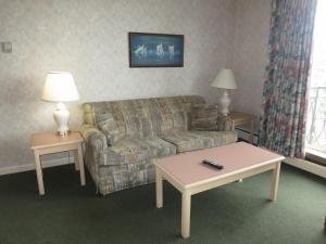 sala de estar con sofá y 2 mesas en Tropicana Suite Hotel, en Vancouver