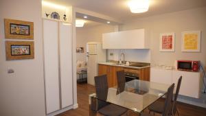 cocina con mesa de cristal en una habitación en Apartamento Vía Romana XIX, en Lugo