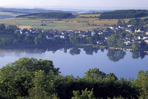 uma pequena aldeia na margem de um lago em Ferienwohnung Seeblick em Schalkenmehren