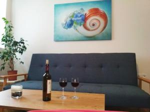 niebieska kanapa z dwoma kieliszkami wina na stole w obiekcie Ηeart of Athens, Solonos str. w Atenach