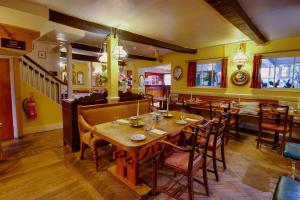 a restaurant with wooden tables and chairs and yellow walls at The Wynnstay in Machynlleth