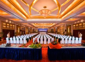 un gran salón de banquetes con filas de mesas y sillas en Huafang Jinling International Hotel Zhangjiagang en Zhangjiagang