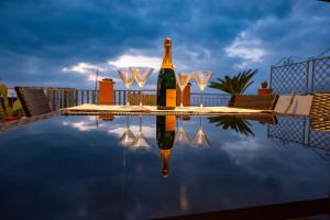 una bottiglia di champagne e bicchieri da vino seduti su un tavolo di Sunset Penthouse a Pizzo