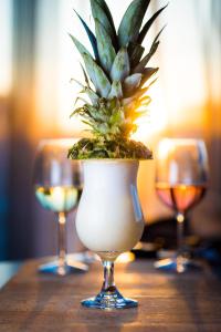 a plant in a vase on a table with three wine glasses at Hestia Hotel Europa in Tallinn
