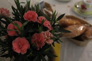 een vaas met roze bloemen op een tafel met brood bij Punto Relax in La Spezia
