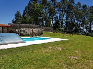 カベセイラス・デ・バストにあるQuinta da Tormenta -14 pessoas- Cabeceiras de Basto 2 casas e piscina privadaの遊び場付きの庭のスイミングプール