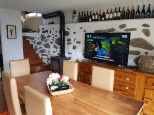 ein Esszimmer mit einem Tisch und einem TV mit Kuchen in der Unterkunft Quinta da Tormenta -14 pessoas- Cabeceiras de Basto 2 casas e piscina privada in Cabeceiras de Basto