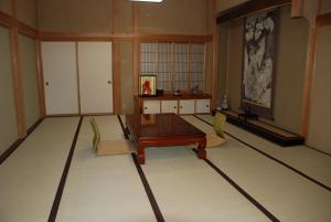 a living room with a table and chairs in it at Oshi Ryokan in Nagano