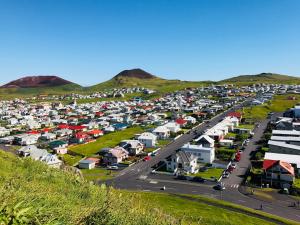 an aerial view of a village in the hills at Guesthouse Árný in Vestmannaeyjar