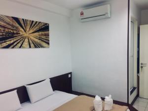 Cette chambre dispose d'un lit et d'une peinture murale. dans l'établissement Api-Api GuestHouse, à Kota Kinabalu