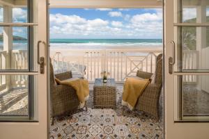 a view of the beach from the balcony of a beach house at Tolcarne Beach Colonial Restaurant and Rooms in Newquay