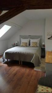 una camera da letto con un grande letto in mansarda di Le Pré Vert a Crugey