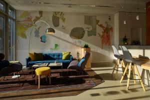 ein Wohnzimmer mit einem blauen Sofa und Stühlen in der Unterkunft Grimm's Berlin Mitte in Berlin