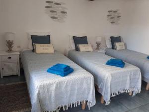 3 posti letto in una stanza con asciugamani blu di Le Pré Vert a Crugey