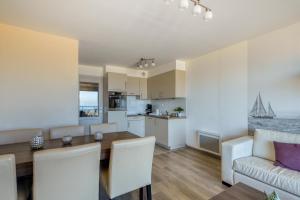 a kitchen and living room with a table and a couch at Evancy Etoile de Mer in Bray-Dunes