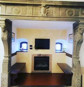 a living room with a fireplace and a flat screen tv at Hotel Fioroni in Bellagio