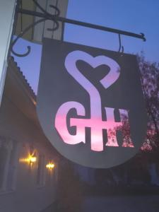 um sinal pendurado num edifício com um sinal de srt em Gasthaus Henri em Raisio