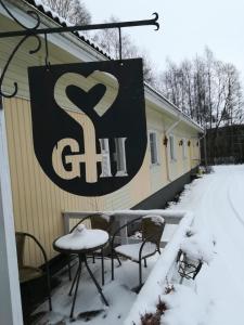 un panneau sur le côté d'une maison dans la neige dans l'établissement Gasthaus Henri, à Raisio