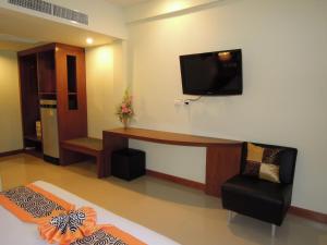 Camera con scrivania e TV a parete. di PS 2 Resort Phuket Patong - SHA Plus a Patong Beach