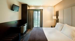 a hotel room with a bed and a television at TURIM Luxe Hotel in Lisbon