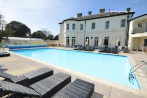a large swimming pool in front of a house at Sandhills Apartments, Mudeford in Christchurch
