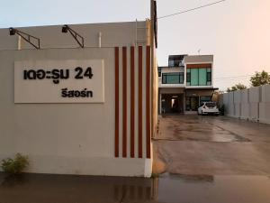 a building with a sign on the side of it at THE ROOM 24 RESORT in Pathum Thani