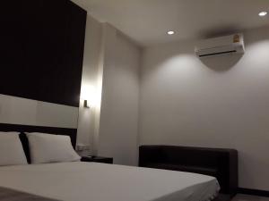a bedroom with a white bed and a heater at THE ROOM 24 RESORT in Pathum Thani