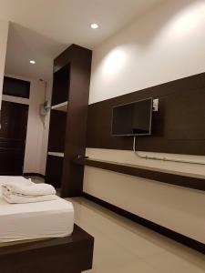 a hotel room with two beds and a flat screen tv at THE ROOM 24 RESORT in Pathum Thani