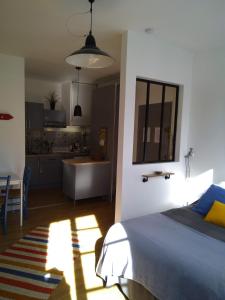 a bedroom with a bed and a kitchen at Le studio de Line in Rochefort