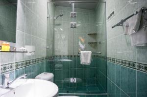 a green tiled bathroom with a sink and a shower at Jahongir in Samarkand +113 photos