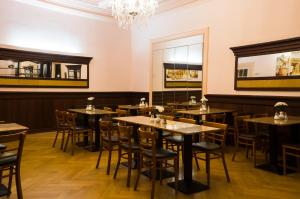 a restaurant with tables and chairs and a chandelier at Hotel Aster an der Messe in Berlin