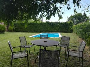 una mesa y sillas en un patio con piscina en Country House El Permanyer, en Olost