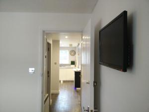 a flat screen tv hanging on a wall in a room at Boutique Coastal appt nr Edinburgh in Saint Davids +5 photos