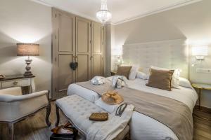 a bedroom with a large white bed with a chair at Hostal Boutique Plaza Cantarero in Nerja
