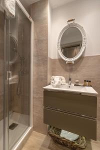 a bathroom with a sink and a shower and a mirror at Hostal Boutique Plaza Cantarero in Nerja