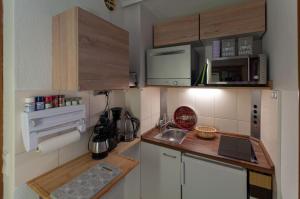 eine kleine Küche mit einer Spüle und einer Mikrowelle in der Unterkunft Harznest in Braunlage