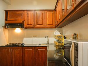 una cocina con armarios de madera y fregadero en Panoramic Holiday Apartment / Seagull Complex | Nuwara Eliya, en Nuwara Eliya